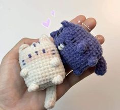 two small crocheted stuffed animals are held in someone's hand