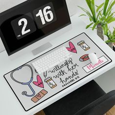 a desk with a clock and keyboard on it next to a plant in a pot