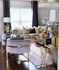 a living room filled with furniture and a chandelier hanging from the ceiling in front of a window