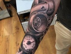 a man with a tattoo on his arm has a speedometer and compass in it