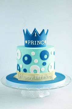 a blue and white birthday cake with a crown on top