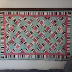 a quilt hanging on the wall above a couch