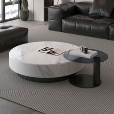 a modern living room with black leather couches and white marble coffee table in the middle