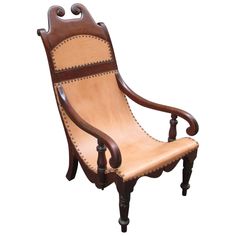 a wooden chair with leather upholstered on the back and arms, sitting against a white background