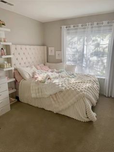 a bedroom with a bed, dressers and window in it's center area