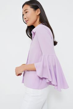 Classic meets cool with the Lilac Norah Bell Sleeve Blouse. Timeless, tried and true details like a crisp collar and a concealed button front placket bring a polished feel — then the addition of those showstopping ruffle cuffs and a silky texture takes the silhouette up a notch and makes it feel exciting and new. Wearable as ever, this top looks perfect with trousers and loafers for a day in the office, or with denim and a tote for weekend wear! Collared neckline Three-quarter length sleeves Sta Semi-formal Collared Tops For Spring, Formal Solid Blouse With Placket, Formal Blouse With Placket, Chic Solid Color Collared Shirt, Chic Solid Collared Shirt, Fitted Solid Color Blouse With Placket, Spring Blouse With Spread Collar And Buttons, Spring Blouse With Buttons And Spread Collar, Solid Color Blouse With Spread Collar For Spring