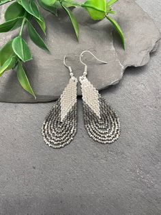 These elegant handwoven earrings are crafted with love using high-quality Delica seed beads. The earrings showcases a graceful teardrop shape with fringe, giving it that trendy boho vibe. With its elegant combination of gray, silver, and frosted color beads, these earrings are truly versatile and will effortlessly complement any outfit or style. Measuring approximately 2.5" in length, they are designed to be lightweight, ensuring comfort throughout the day. ♥  All orders come beautifully hand-packaged with care, making it the perfect gift for yourself or someone special.  ♥  Each piece is handmade with love in my home studio in Rockaway, NJ. Silver Teardrop Beaded Earrings With Faceted Beads, Teardrop Beaded Earrings For Jewelry Making, Teardrop Beaded Earrings With Faceted Beads, Silver Teardrop Beaded Earrings With Ear Wire, Silver Beaded Long Drop Earrings, Gray Beaded Dangle Earrings, Silver Beaded Teardrop Earrings As Gift, Silver Beaded Teardrop Earrings For Gift, Silver Beaded Teardrop Chandelier Earrings