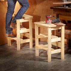 a man standing on top of two stools next to a workbench and tools