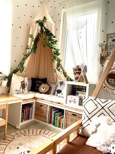 a child's room with a teepee tent and bookshelf