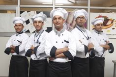 five chefs are standing in front of a wall with their arms crossed and looking at the camera