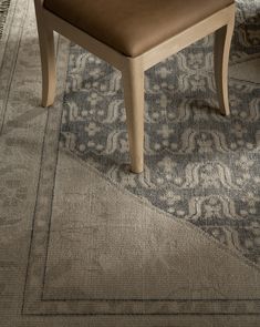 a brown chair sitting on top of a rug