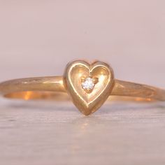 The Fifty: Natural Diamond Heart Ring In Yellow Gold. This Simple Ring Centers On A Round-Cut Natural Diamond, Beautifully Set Within A Concave Heart Shape Crafted In Yellow Gold. Currently Sized At 5.25, The Ring Can Be Adjusted To Fit Any Finger Size For An Additional Fee Upon Request, Ensuring A Perfect Fit. Wedding Heart Ring With Single Diamond, Heart-shaped Single Diamond Ring Gift, Heart Shaped Single Diamond Ring For Gift, Heart Shaped Single Diamond Gift Ring, Diamond Heart Ring With Single Diamond For Wedding, Heart-shaped Single Diamond Gift Ring, Heirloom Diamond Heart Ring, Classic 14k Gold Heart Ring With Single Diamond, Heart-shaped Single Diamond Fine Jewelry Ring