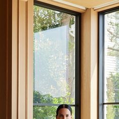 a woman sitting on a chair in front of a window