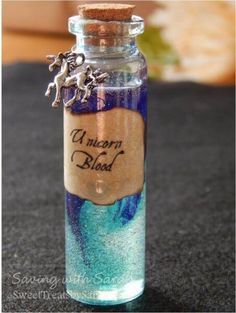 a glass bottle with some writing on it and a horse charm hanging from the top