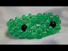 a green bracelet with black beads on it