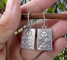 Beautifully detailed Tarot Cards dangle from silver plate Lever Back Ear Wires. The Sun and La Luna are depicted on a pair of double sided silver tarot cards. One of my very favorite designs, these fortune teller earrings are both elegant and edgy, a perfect combination and the ideal gift for mystical folks on you list.  Your Tarot Card Earrings will arrive in an organza pouch with a matching polishing cloth.  Use code 3GETS20 to receive a 20% discount every time you order 3 or more items from A Tarot Card Earrings, Tarot Earrings, Card Earrings, Earrings Goth, Earrings Ideas, Handmade Clay Jewelry, Dragon Earrings, Organza Pouch, Jewellery Silver