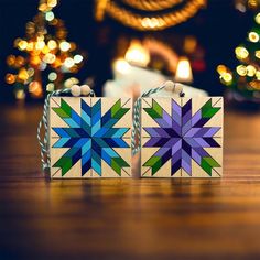 two wooden blocks are sitting next to each other on a table with christmas lights in the background