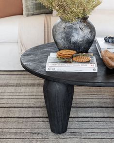 a coffee table with cookies and crackers on it next to a potted plant