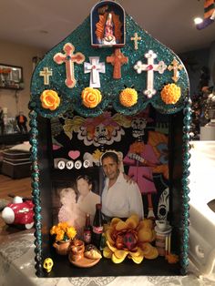 an altar with flowers, candles and pictures on the front is decorated in turquoise sequins