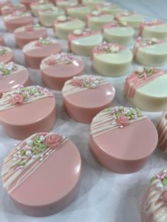 many pink and white decorated cookies on a table