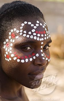 a woman with black face paint and white dots on her face is looking at the camera