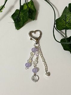 a heart shaped keychain hanging from a plant