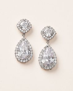 Designed to bring a touch of luxury and sophistication, our Allure CZ Earrings are the perfect accessory for any special occasion. Details: Cushion cut and pear shaped cubic zirconia stones are surrounded by halos of small CZs for maximum sparkle. Specifications: 1.5" long. Extremely lightweight and easily worn all day and evening. Tarnish Resistant: Earrings are tarnish resistant for long lasting shine. Hypoallergenic: Earrings are hypoallergenic, lead-free & nickel-free. Style #1142 Wedding Earrings Silver, Silver Bridal Jewellery, Silver Earrings Wedding, Crystal Earrings Wedding, Freshwater Pearl Drop Earrings, Silver Statement Earrings, Wedding Earrings Drop, Easy Day, Sparkle Earrings