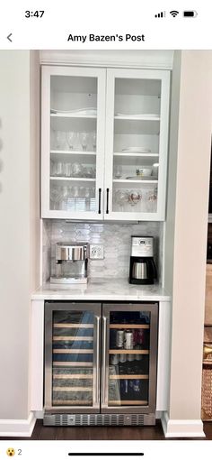 a kitchen with two wine coolers in the middle and an open cabinet above it