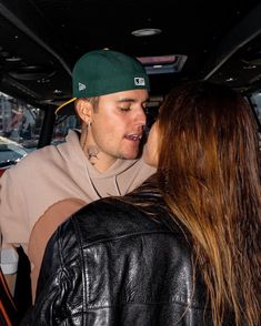 a man and woman kissing in the back of a car