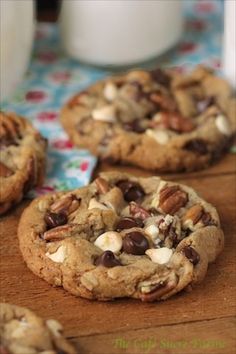 chocolate chip cookies with nuts and almonds on a wooden cutting board