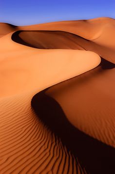 sand dunes in the desert under a blue sky