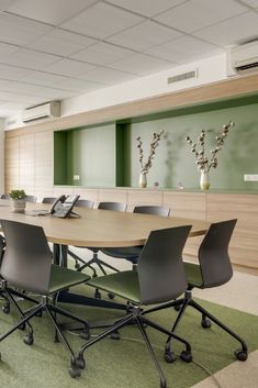 an empty conference room with green carpeting and wooden paneled wall behind the table