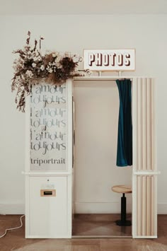 a room with a sign and some flowers on the shelf next to an open door