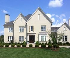 a large white house sitting on top of a lush green field