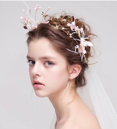 a woman wearing a veil with flowers in her hair and a tiara on her head