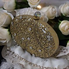 Introducing our Seashell Clutches- a true masterpiece of elegance. These oval and rectangular shaped clutches features a luxurious gold frame, adorned with exquisite ivory acrylic seashell, complemented by meticulous peals embellishments on brass floral work that adds a touch of sophistication. The inner lining, crafted with plush suede fabric, enhances the tactile experience, making it as delightful to touch as it is to behold. The meticulous attention to detail extends to the heavy premium quality chain, ensuring a seamless blend of style and practicality. With dimensions of 7 inches in length, this clutch strikes the perfect balance between compactness and functionality. Elevate your ensemble with the enchanting allure of the "Seashell" - a timeless accessory that embodies opulence and Gold Embroidered Clutch For Wedding, Elegant Evening Bag With Gold Embroidery For Reception, Luxury Clutch With Gold Embroidery For Reception, Luxury Gold Embroidered Clutch For Reception, Wedding Clutch With Gold Embroidery, Elegant Gold Clutch For Wedding, Rectangular Clutch For Wedding, Luxury Gold Clutch For Formal Occasions, Traditional Gold Clutch For Wedding