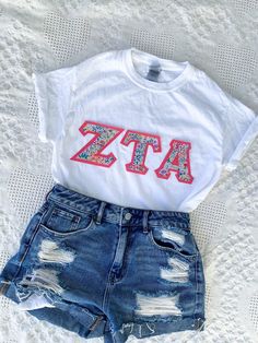 a t - shirt with the letters atta on it and some cut off denim shorts