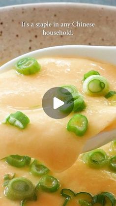 a white bowl filled with soup and green peppers on top of it's side