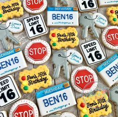 many decorated cookies are arranged in the shape of road signs and stop signs on display