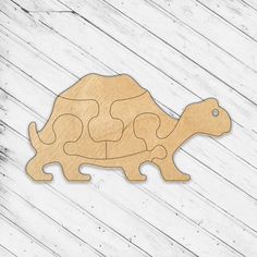 a wooden cutout of a tortoise on a white wood background with planks