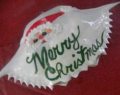 a merry christmas sign with santa clause on it's face and the words merry christmas written in green