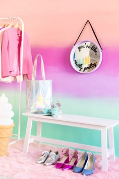 an ice cream shop with pink and blue ombreaches on the wall, two white benches in front of them