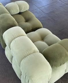 a large green couch sitting on top of a floor