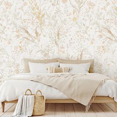 a bed with white sheets and pillows in front of a floral wallpaper