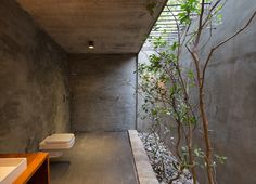 a bathroom with concrete walls and flooring next to a toilet