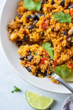 a white bowl filled with rice and black beans, garnished with cilantro