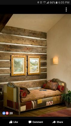 a bed sitting in the middle of a living room next to a wall with pictures on it