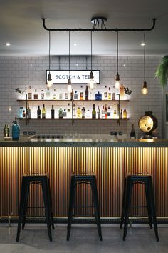 an image of a bar with stools in the foreground and lights above it