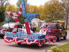 a parade float with an american flag and star on it's back in the street