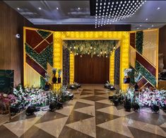 an elaborately decorated hall with flowers and greenery